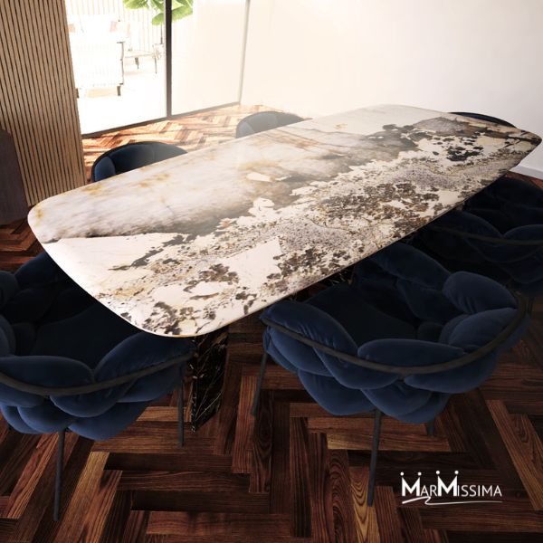Tavolo design in marmo pregiato con venature naturali dorate e scure, circondato da sedie in velluto blu, ideale come arredo di lusso per sala da pranzo moderna con pavimento in parquet elegante